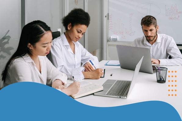 A team of professionals collaborating at a conference table with laptops and notes, discussing digital healthcare trends and data shown on a whiteboard in the background.
