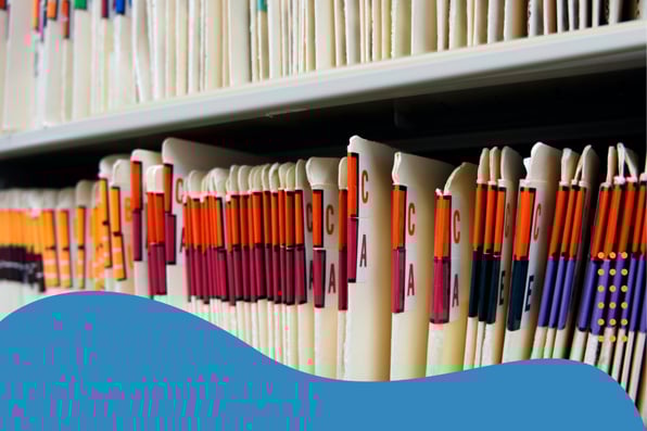 Color-coded paper medical records organized by letter tabs, representing healthcare documentation and retention practices for LTPAC compliance.
